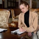 Documente de proprietate și un extras de registru imobiliar examinate cu o lupă pe un birou